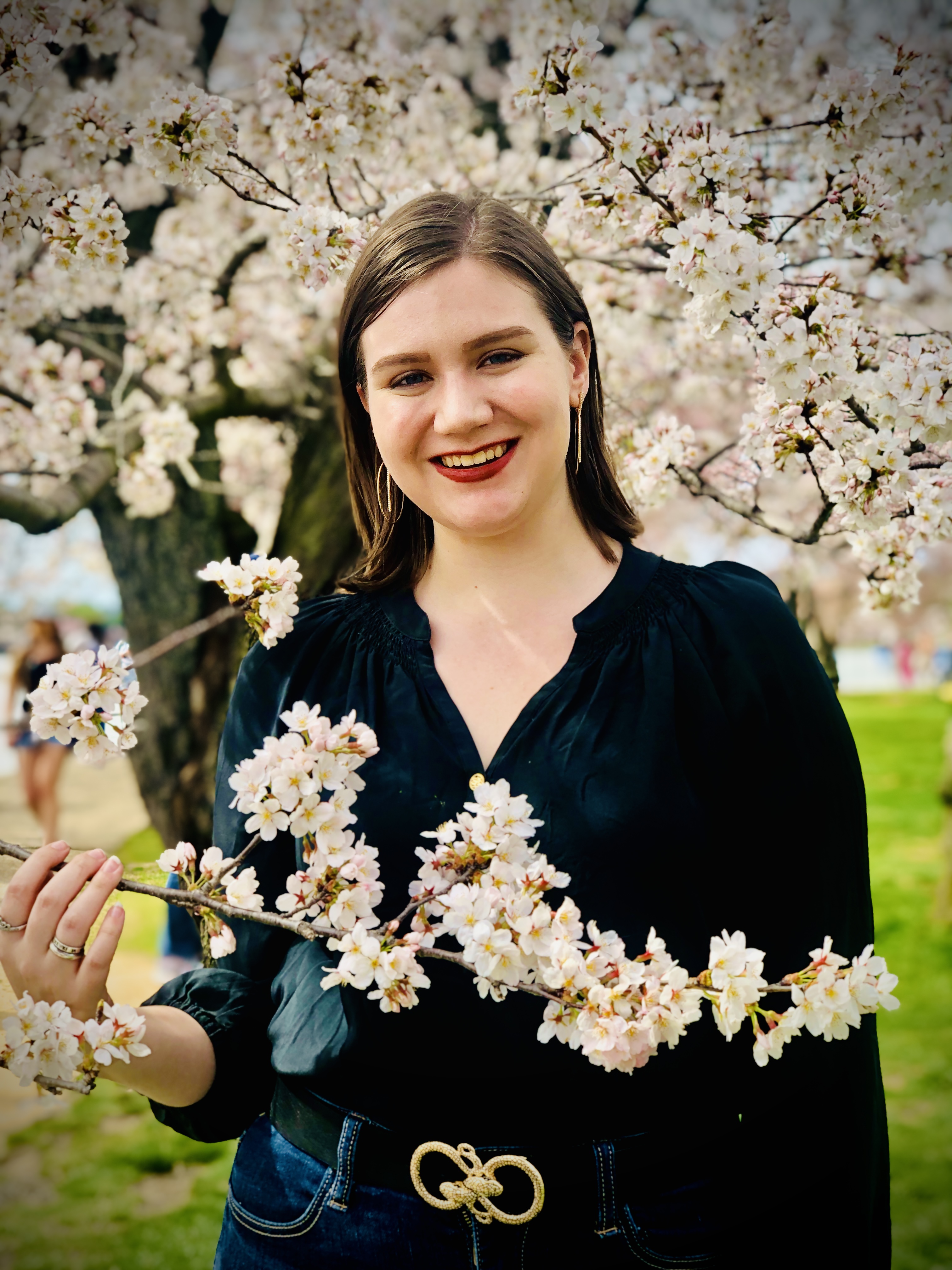 short brown hair girl in front of cherry blossom tree